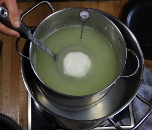 Place the closed packet on the ladle, with the overlapped edges down and immerse the bottom into the hot whey for a few moments, this seals the packet 